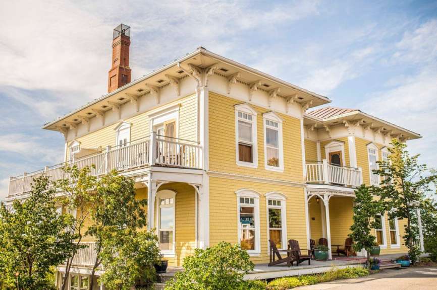 Ein großes gelbes Haus mit einem roten Schornstein