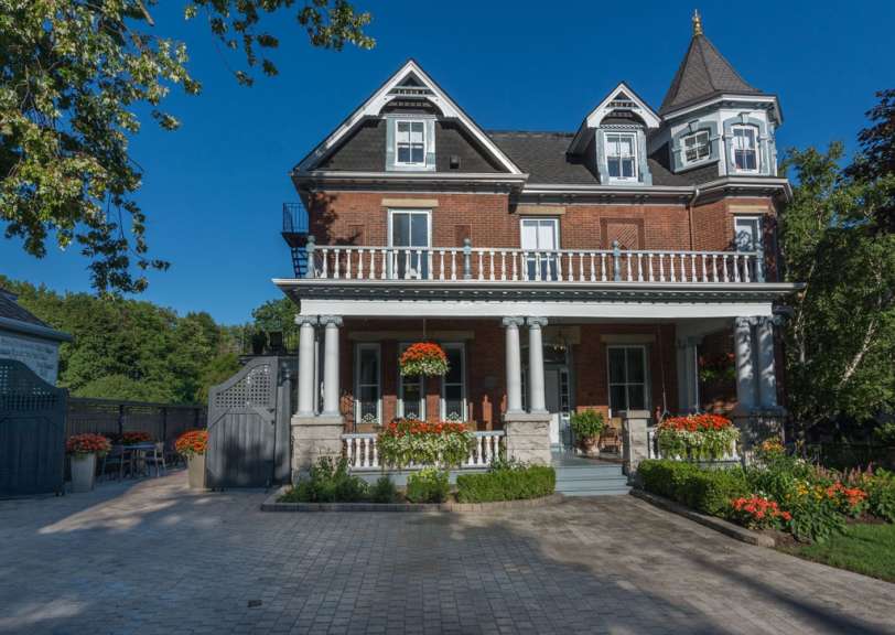 Ein großes Backsteinhaus mit einer großen Veranda