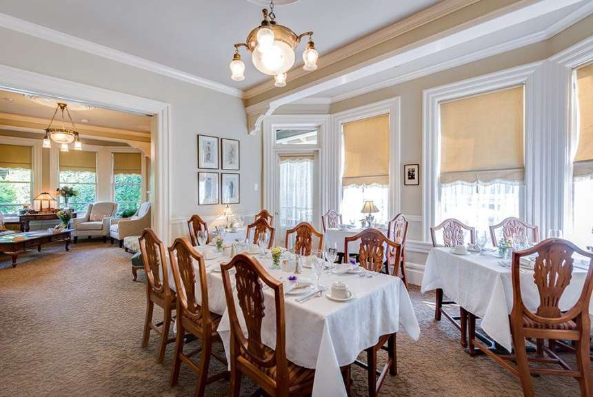 Ein Esszimmer mit Tischen und Stühlen und einem Kronleuchter