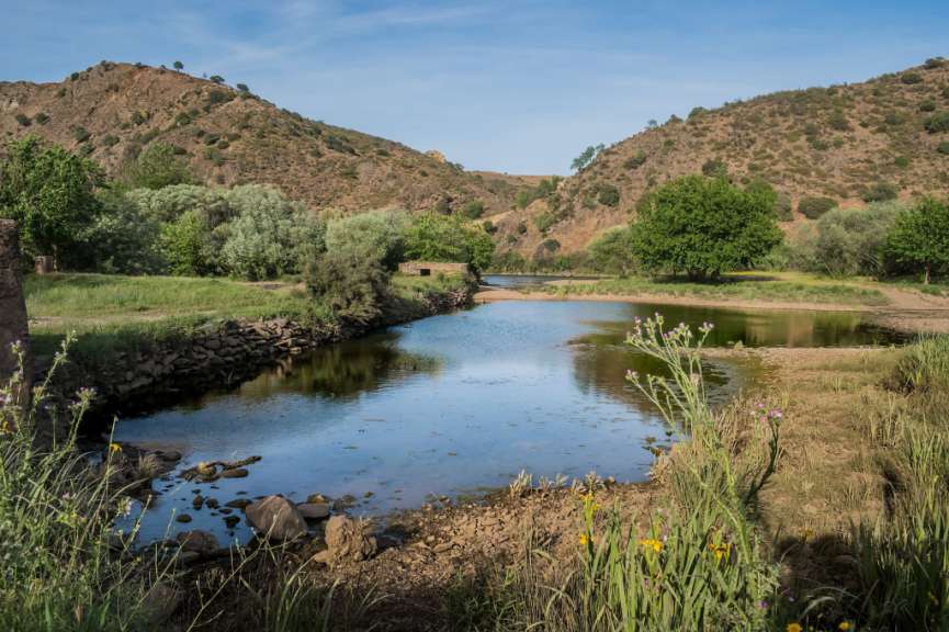 Ein Fluss läuft zwischen zwei Hügeln hindurch