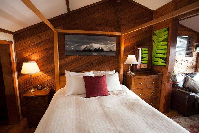 Ein Schlafzimmer mit einem Himmelbett und einem Gemälde an der Wand
