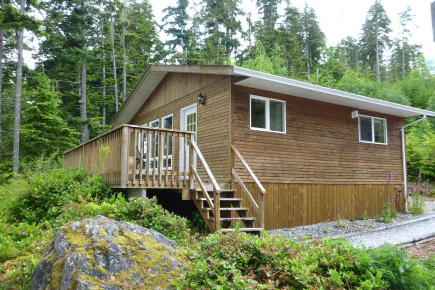 Ein kleines Holzhaus mit einem großen Deck im Wald