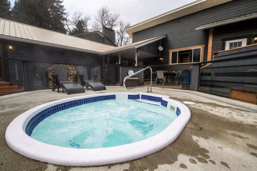 Ein Whirlpool mit blauen Fliesen steht vor einem Haus
