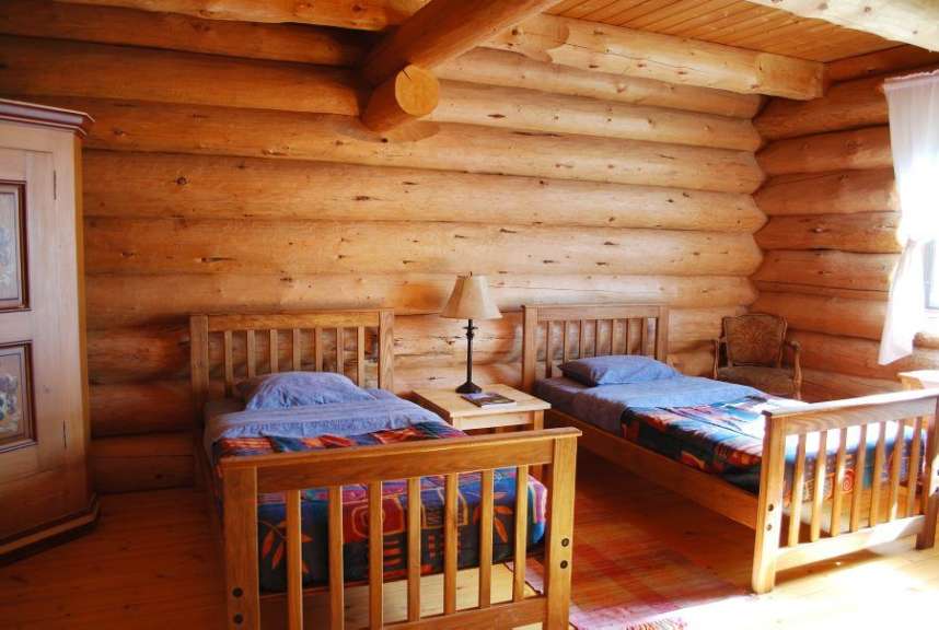 Ein Blockhaus mit zwei Einzelbetten und einer Lampe