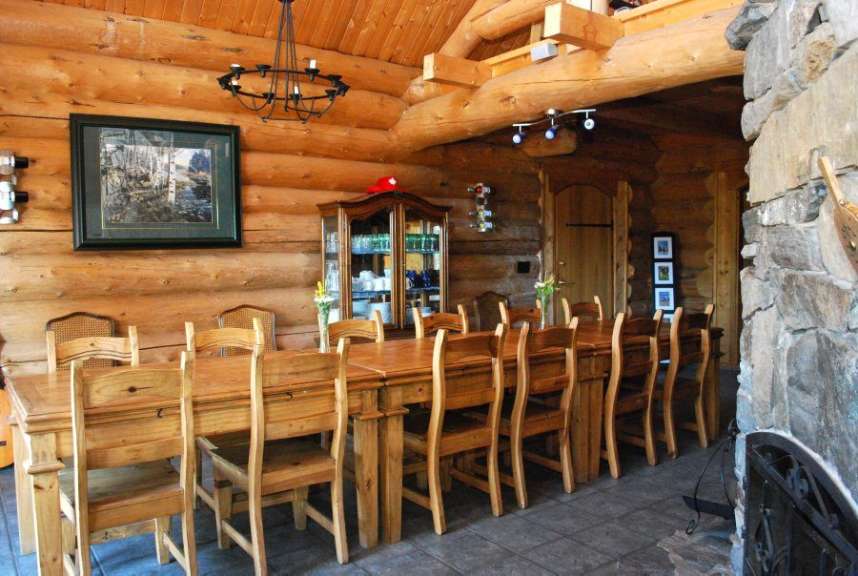 Ein langer Holztisch und Stühle in einem Blockhaus