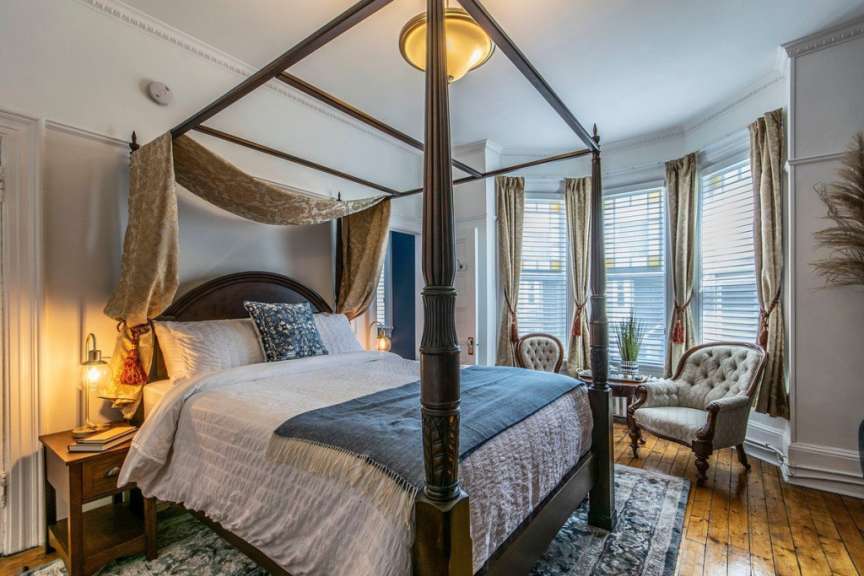 Ein Schlafzimmer mit einem Himmelbett und einem Stuhl