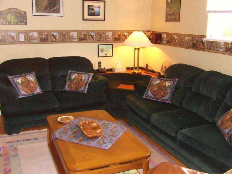 Ein Wohnzimmer mit zwei grünen Sofas und einem Couchtisch