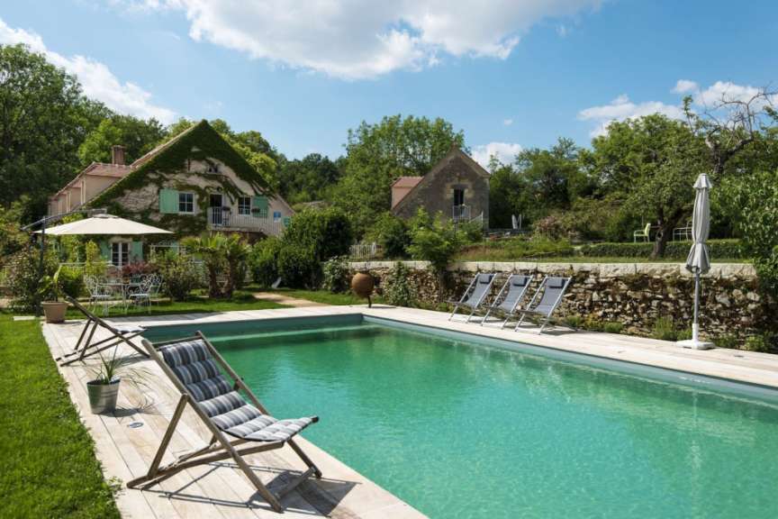 Liegestühle und Sonnenschirme um einen großen Swimmingpool