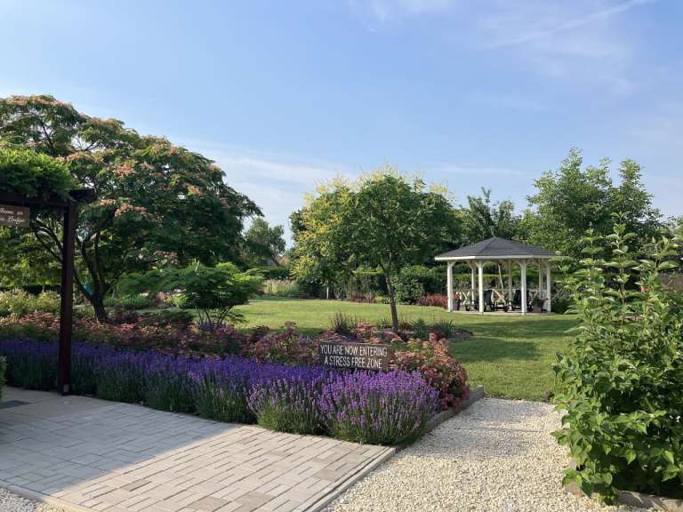Ein Garten mit lila Blüten und einem Zeichen, das sagt, dass Sie ein stressfreies Zuhause haben