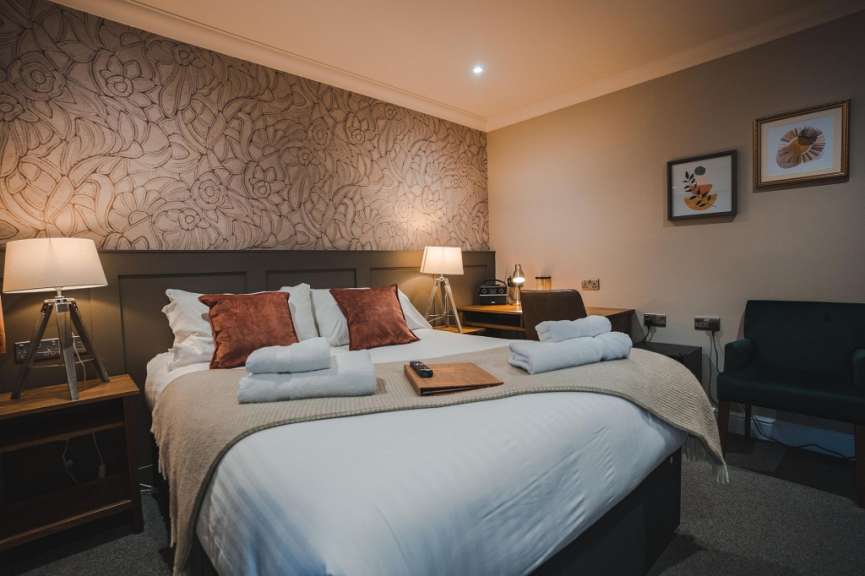 Ein Hotelzimmer mit einem Bett, einem Schreibtisch und einem Sessel.