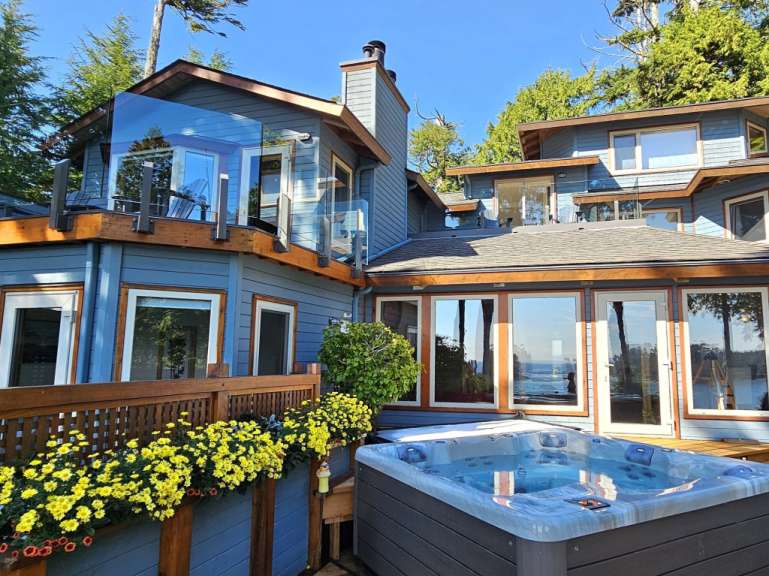 Ein großes Haus mit vielen Fenstern und einer Jacuzzi im Vordergrund