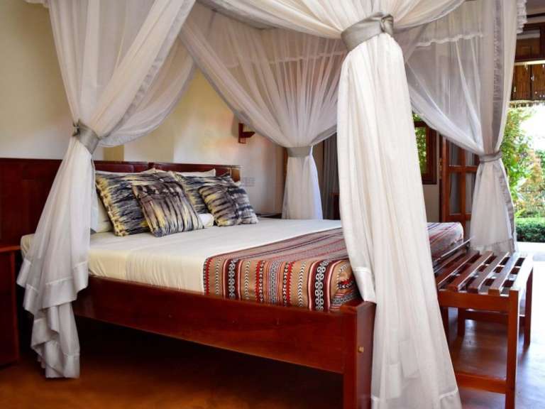 Ein Schlafzimmer mit Himmelbett und weißen Vorhängen
