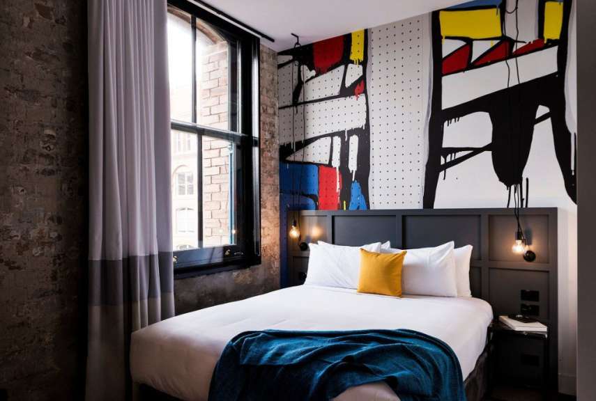 Ein Schlafzimmer mit einem Bett und einem Gemälde an der Wand