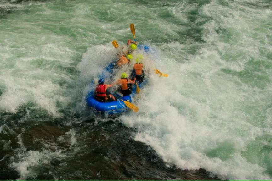 Eine Gruppe von Menschen in einem Floß, das durch einen Fluss fährt