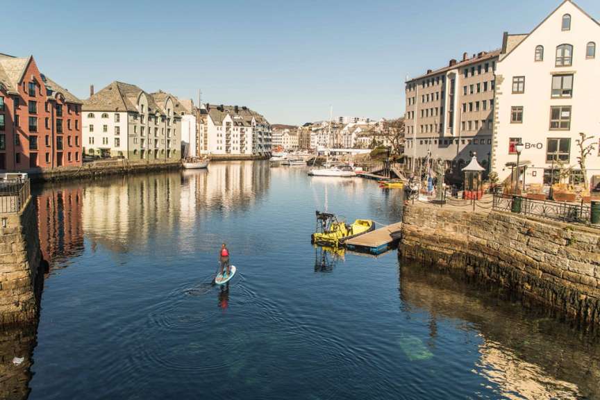 Eine Person paddelt auf einem Paddleboard in einem Fluss