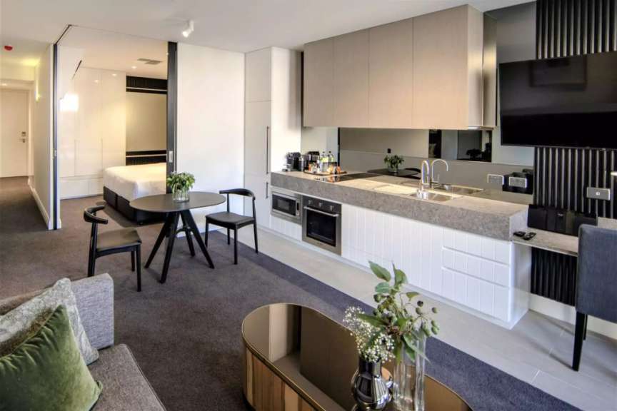 Ein Wohnzimmer mit einem Tisch und Stühlen neben einer Küche