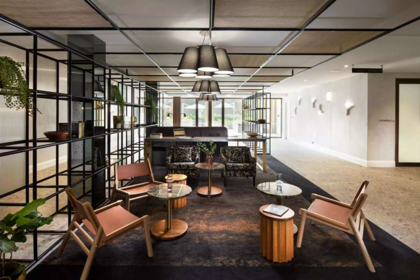 Ein Wohnzimmer mit vielen Stühlen und Tischen
