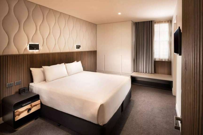 Ein Hotelzimmer mit einem Bett und einem Nachttisch