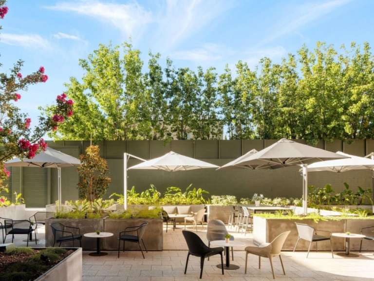 Eine Terrasse mit Tischen und Stühlen und Regenschirmen