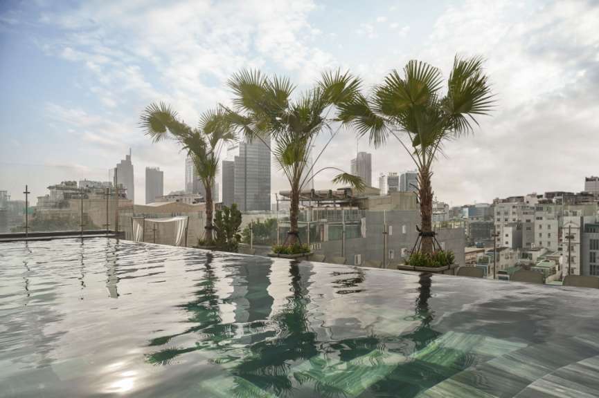 Ein Pool mit Palmen und Gebäuden im Hintergrund