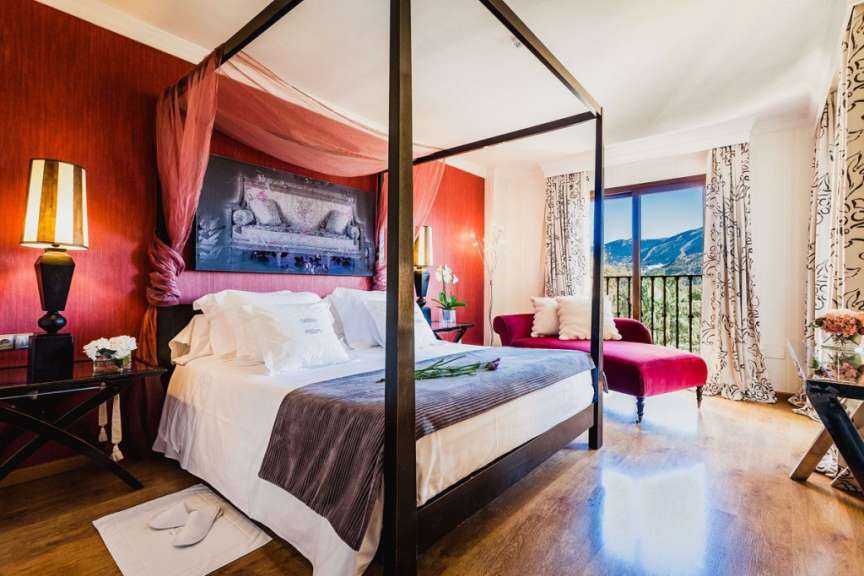 Ein Schlafzimmer mit einem Himmelbett und einem roten Stuhl