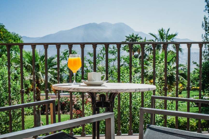 Ein Tisch mit einer Tasse Kaffee und einem Glas Orangensaft auf einem Balkon