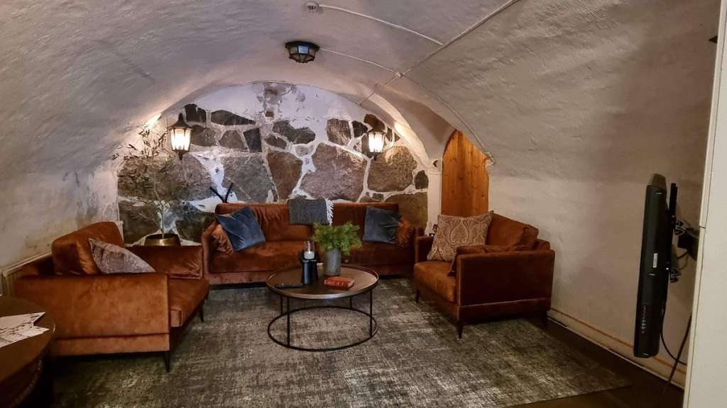Ein Wohnzimmer mit Couch und Stühlen und einem Fernseher