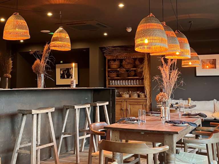 Ein Restaurant mit einem Tisch und Stühlen und vielen Lampen