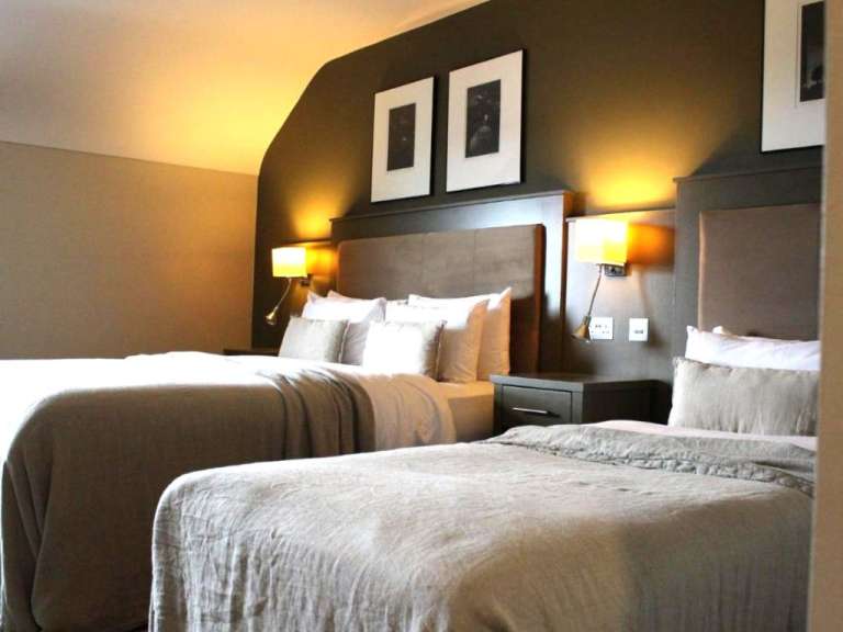 Ein Hotelzimmer mit zwei Betten und zwei Bildern an der Wand