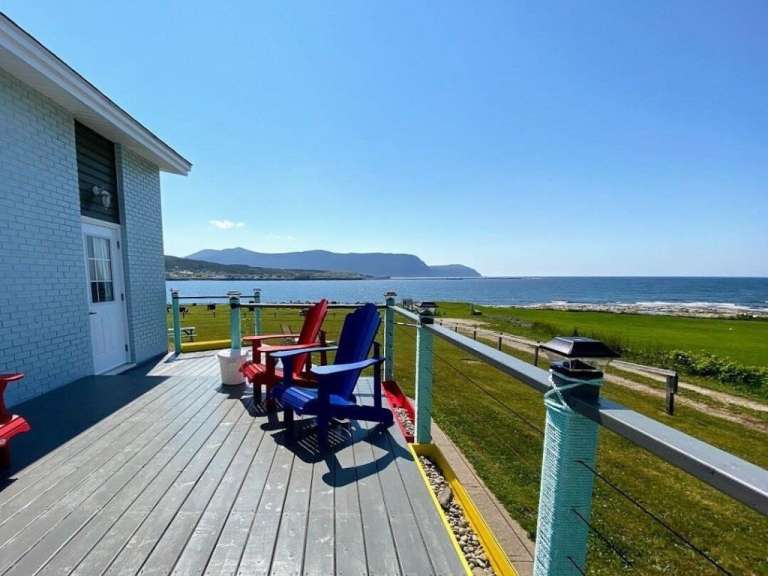Eine Reihe von Stühlen auf einem Deck mit Blick auf das Meer
