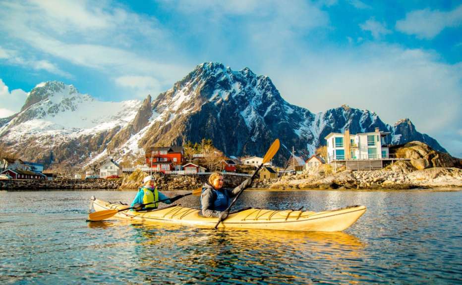 Eine Frau und ein Kind paddeln in einem See mit Bergen im Hintergrund