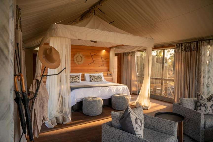 Ein Schlafzimmer mit Himmelbett und Stuhl