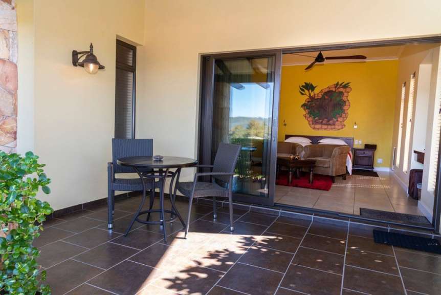 Eine Terrasse mit einem Tisch und Stühlen und einem Schlafzimmer dahinter