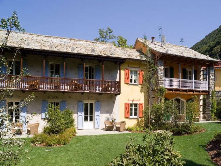 Ein Haus mit blauen Fensterläden und einem Balkon