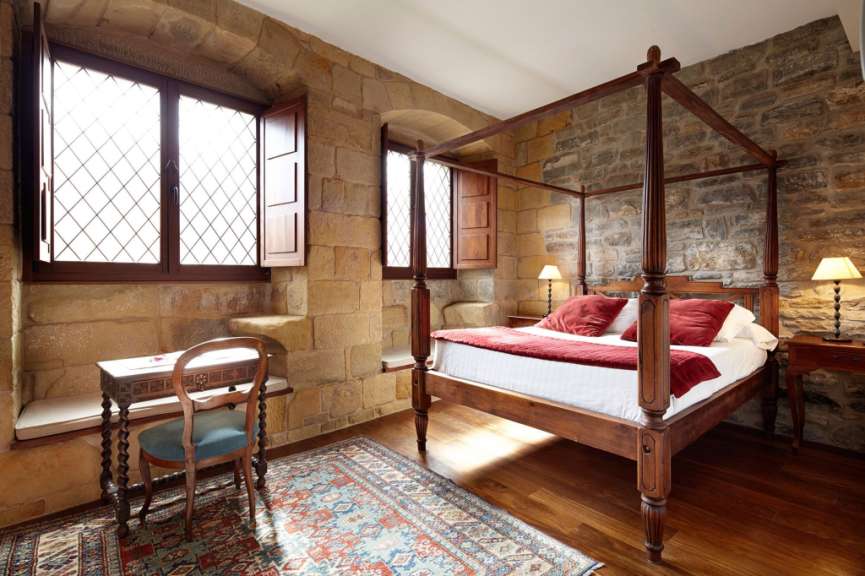 Ein Schlafzimmer mit einem Himmelbett und einem Schreibtisch