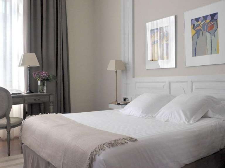 Ein Schlafzimmer mit einem Bett und zwei Bildern an der Wand
