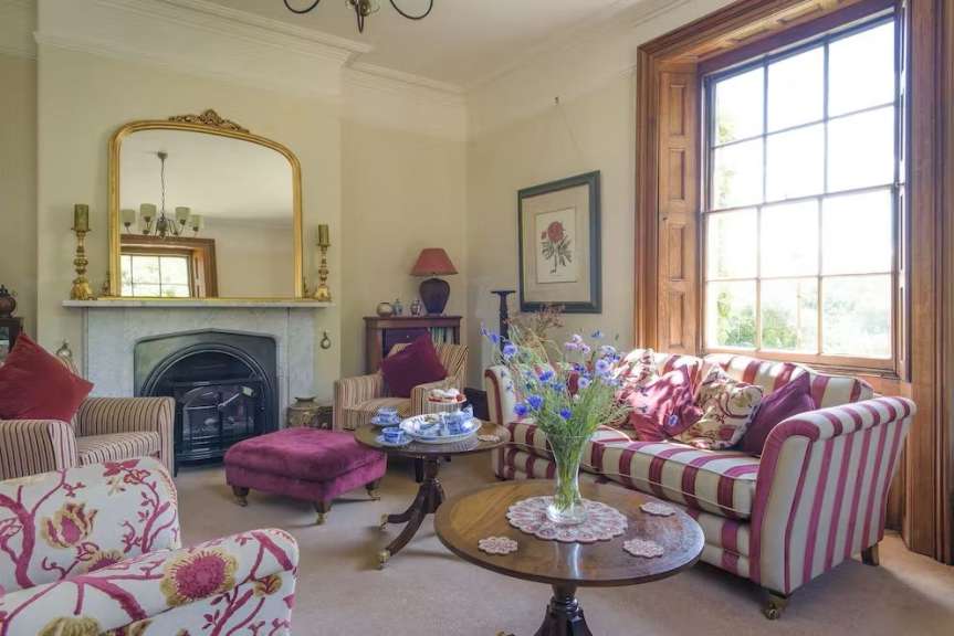 Ein Wohnzimmer mit gestreiften Möbeln und einem Kamin