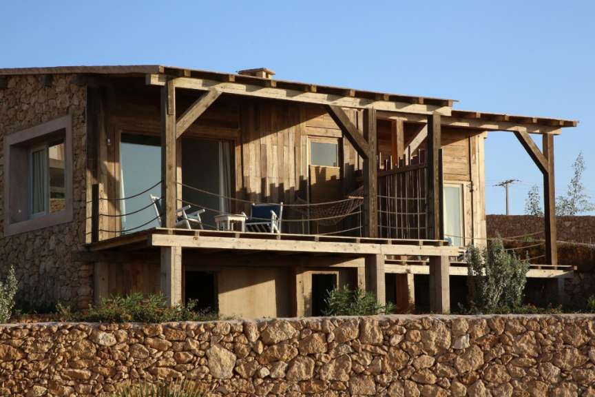 Ein kleines Holzhaus mit einer Steinmauer dahinter