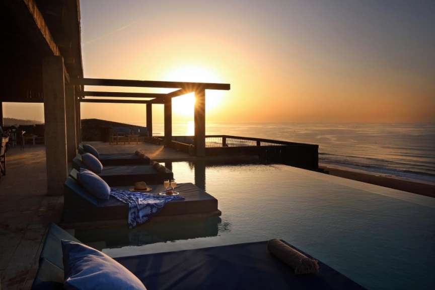Ein Infinity-Pool mit Blick auf den Ozean bei Sonnenuntergang
