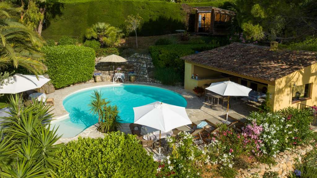 Ein großer Swimmingpool umgeben von weißen Sonnenschirmen und Möbeln