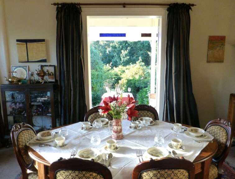 Ein Speisesaal mit einem Tisch und Stühlen und einem Fenster