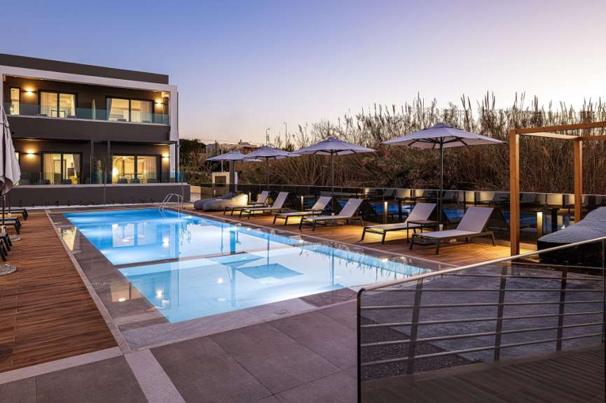 Ein großer Pool mit Liegestühlen und Sonnenschirmen umgeben