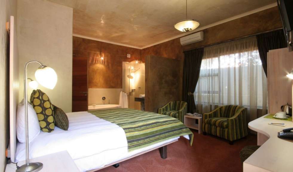 Ein Hotelzimmer mit einem Bett und zwei Stühlen