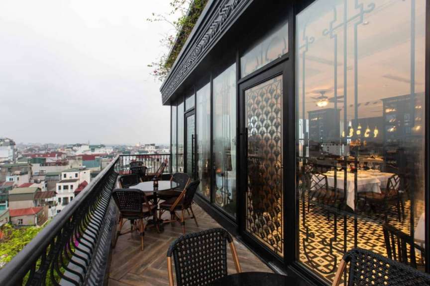 Tische und Stühle auf einem Balkon mit Blick auf die Stadt