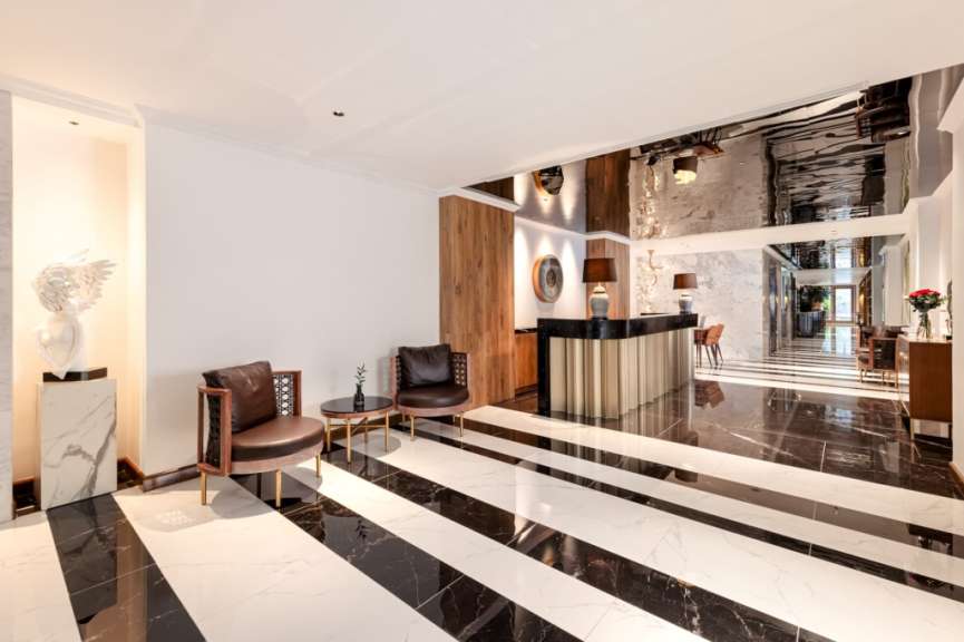 Eine moderne Lobby mit auffälligem schwarz-weißen Boden, einer Rezeptionstheke und Sitzgelegenheiten.