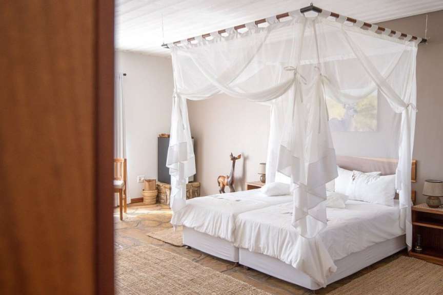 Ein Bett mit weißen Bettwäschen und einem weißen Himmelbett