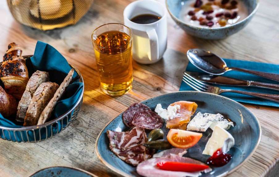 Auf einem holztisch steht ein teller mit fleisch und käse