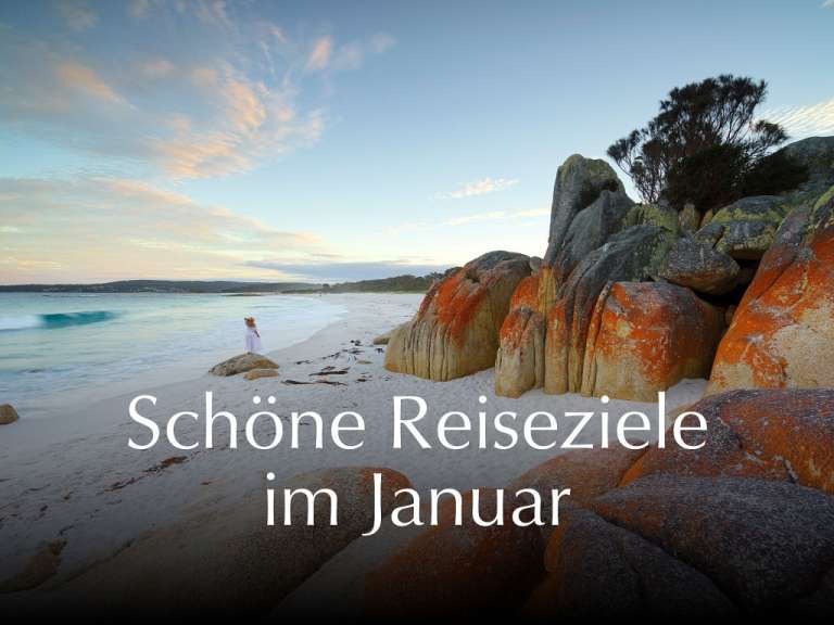 Eine Frau steht an einem Strand mit der Aufschrift schöne reiseziele im januar