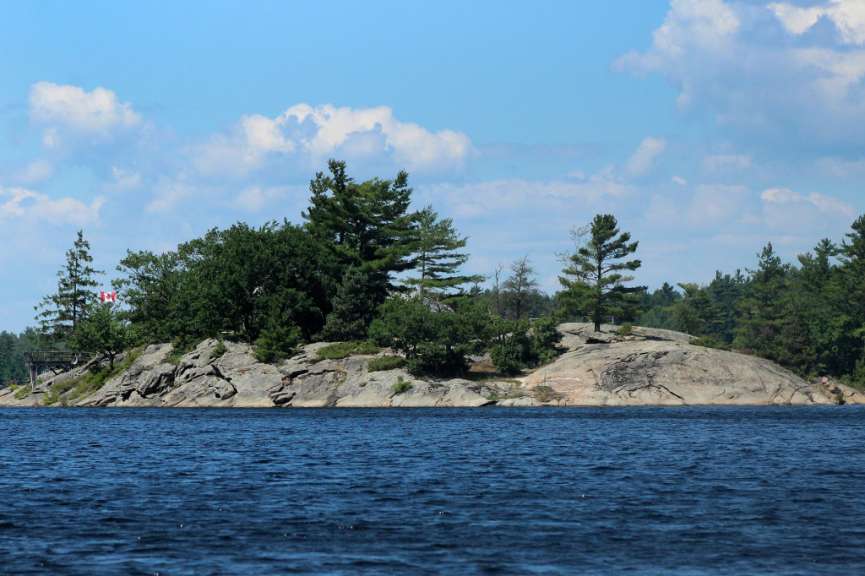 Eine kleine Insel im Wasser mit einer kanadischen Flagge darauf