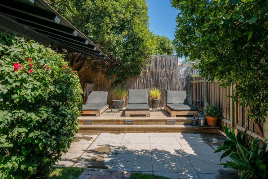 Eine Terrasse mit Liegestühlen und einem Zaun
